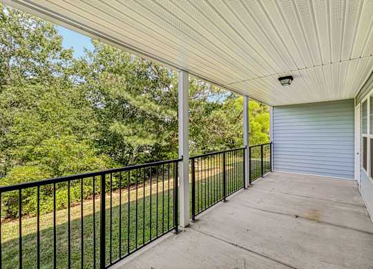 A balcony with a black railing and a white ceiling.
