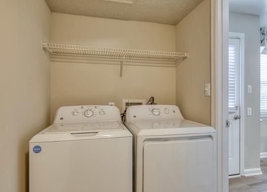 A small laundry room with a washer and dryer.