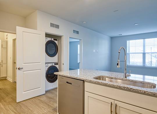 A modern kitchen with a washer and dryer built into the cabinetry.
