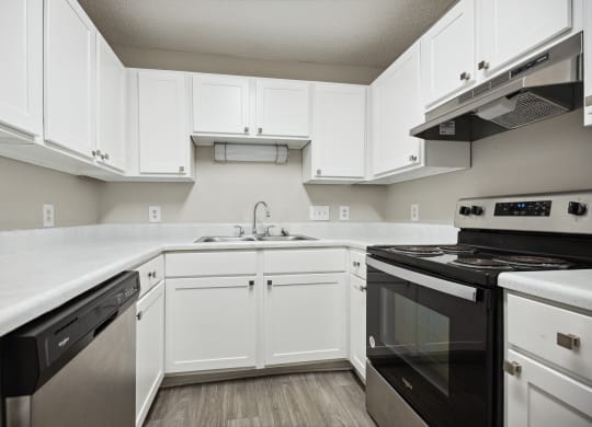 a kitchen with white cabinets and black appliances