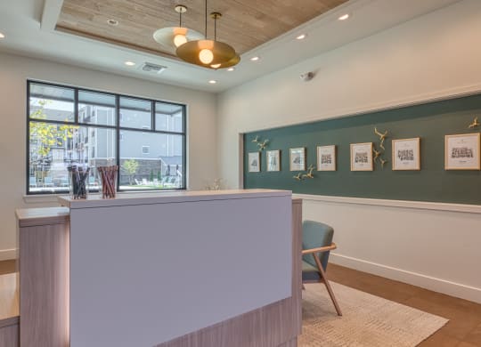 a reception area with a green wall and a desk with a chair