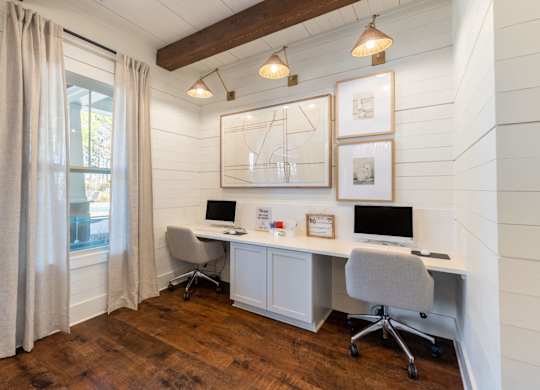 A room with two computers and a desk.
