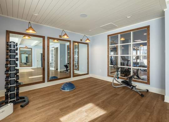 A gym room with a mirror, a bench, and a treadmill.
