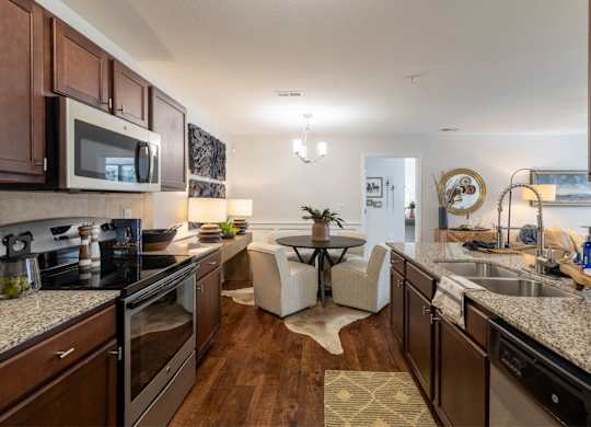 A modern kitchen with dark wood cabinets and granite countertops.