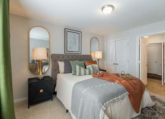 A bedroom with a bed, nightstand, and two lamps.