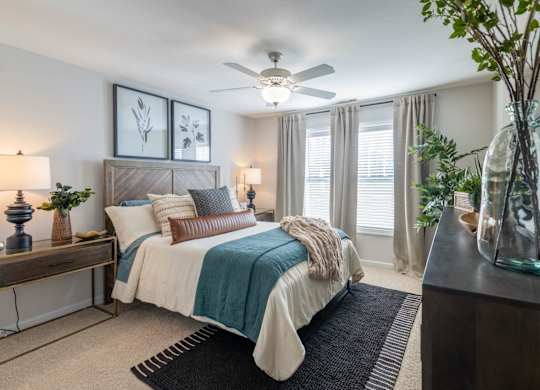 A bedroom with a bed, a nightstand, and a ceiling fan.