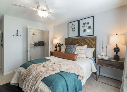 A bedroom with a bed covered in a white and blue comforter.