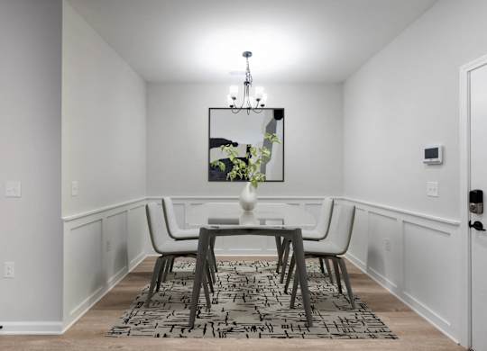 A dining room with a table and chairs.