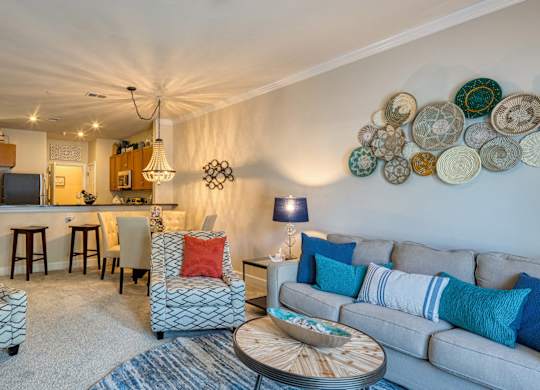 A living room with a grey couch, a patterned armchair, and a coffee table.