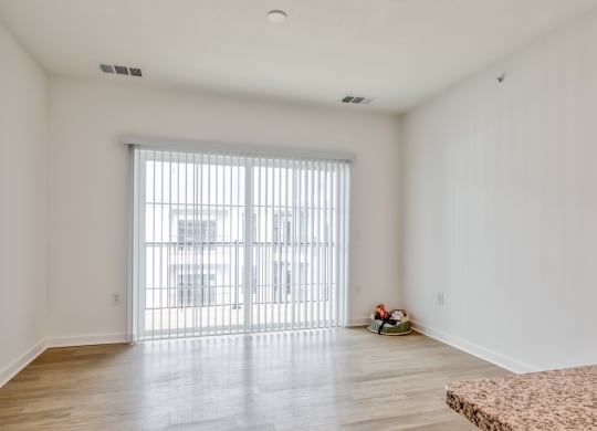 a living room with white walls and a sliding glass door at Allure at Edinburgh, Virginia