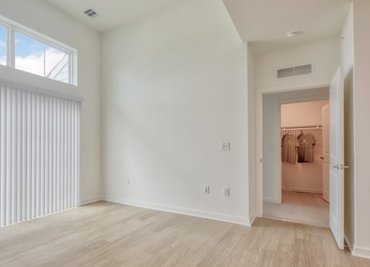an empty living room with white walls and a large window at Allure at Edinburgh, Virginia
