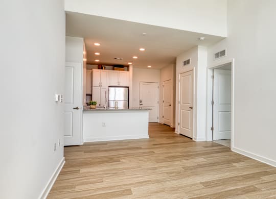 a living room and kitchen with white walls and wood flooring at Allure at Edinburgh, Chesapeake, VA, 23322