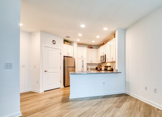 a living room with a kitchen and a blue counter top at Allure at Edinburgh, Virginia