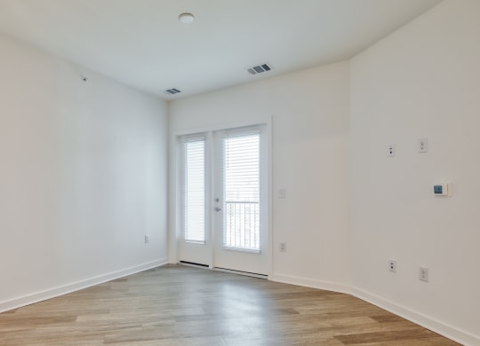 a living room with white walls and a door to a balcony at Allure at Edinburgh, Virginia, 23322