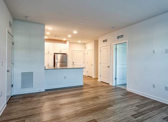 A kitchen with white cabinets and a wooden floor.