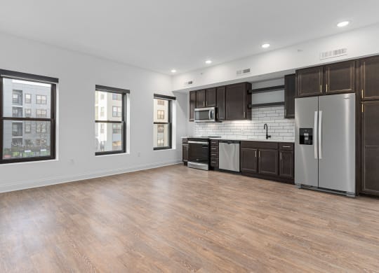 an empty kitchen with stainless steel appliances and dark wood cabinets at The Madison, Columbus, OH, 43215
