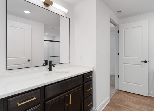 a bathroom with a large mirror and a sink and a toilet at The Madison, Columbus