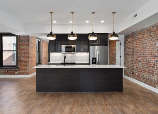 a kitchen with a large island and a brick wall at The Madison, Ohio, 43215