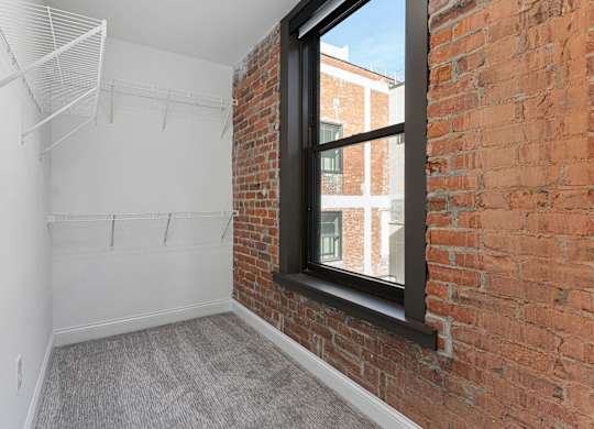 A room with a brick wall and a window.