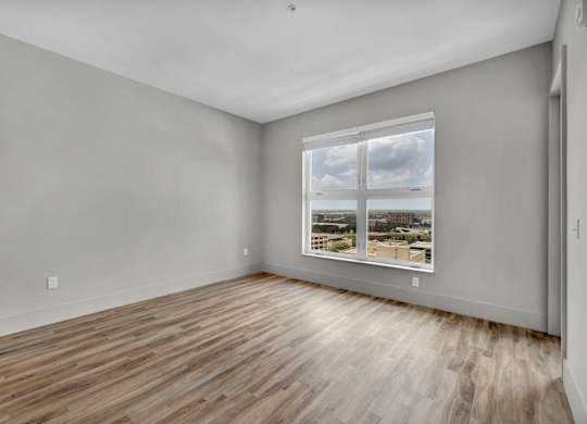 Empty room with a window showing a cityscape outside.