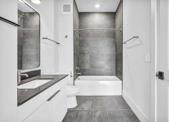 A bathroom with a white tub and toilet.