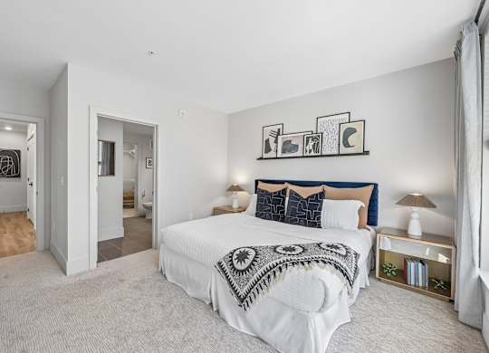A bedroom with a large bed and a wall art.