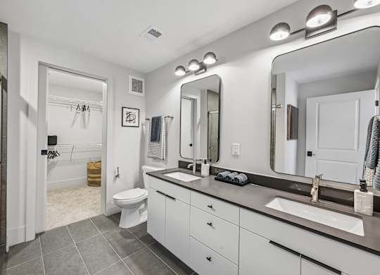 A bathroom with a white toilet, sink, and mirror.
