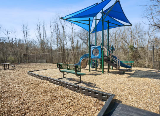 a playground with a blue structure and benches