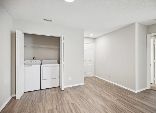 the spacious living room and laundry room with washer and dryer