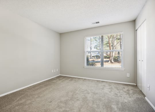 an empty room with carpet and a window
