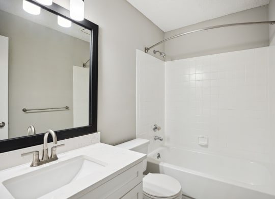 a white bathroom with a white sink and a tub and a white toilet