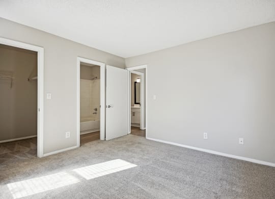 an empty living room with an open door to a bathroom