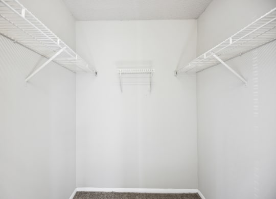 an empty room with white walls and white racks on the wall