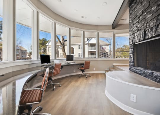 a large office with a fireplace and a wall of windows