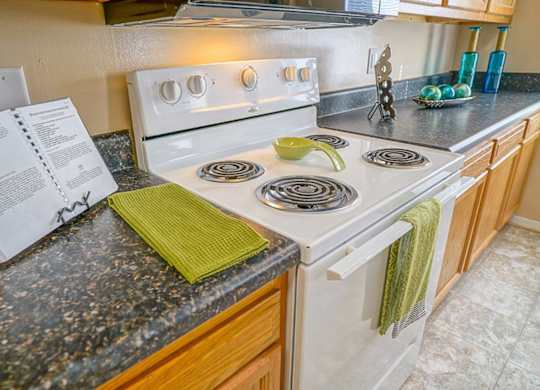 A white stove top oven with a green towel on it.