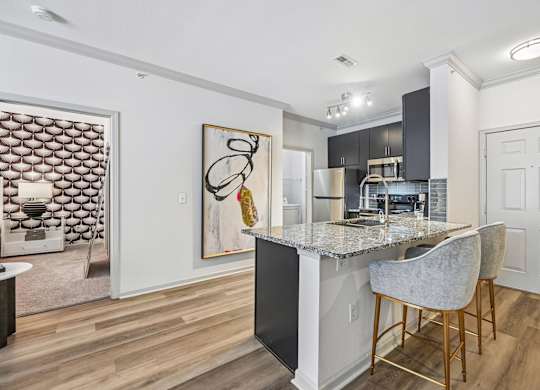 A kitchen with a bar stool and a painting on the wall.