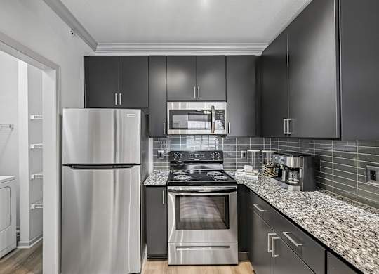 A modern kitchen with a stainless steel refrigerator and oven.
