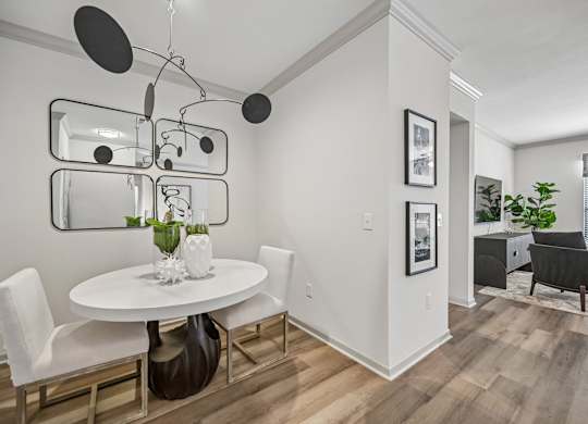 A modern dining room with a white table and chairs.