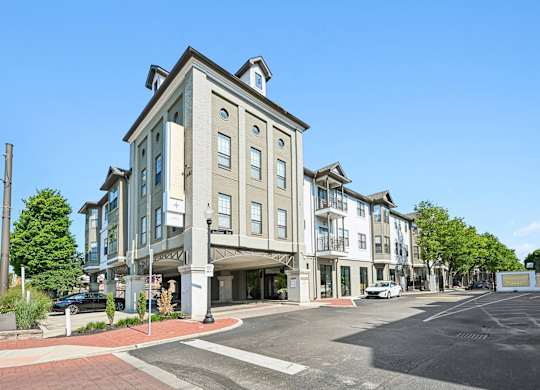 A street view of a residential building with a clear blue sky.