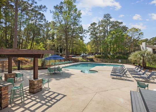 the resort style pool is surrounded by chairs and umbrellas