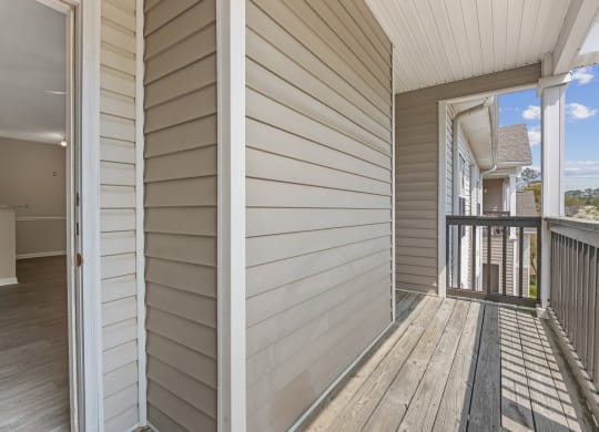 two photos of a porch with white wooden walls and a balcony