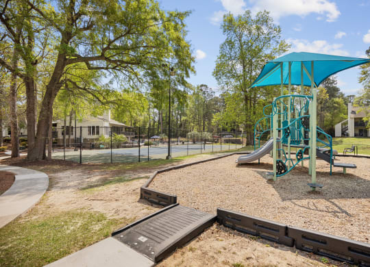 a playground with a swing set and a slide in a park
