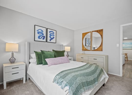 a bedroom with a white bed and green pillows