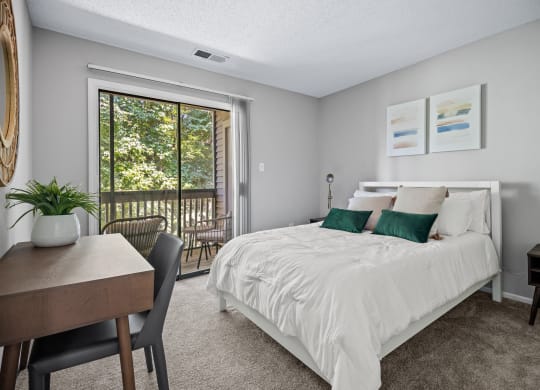 a bedroom with a bed and a door to a balcony