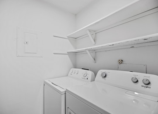 a washer and dryer in a white room with a white wall and a