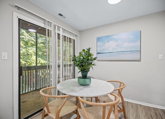 a dining area with a table and chairs and a door to a balcony