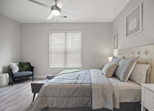 A bedroom with a bed, dresser, and chair.