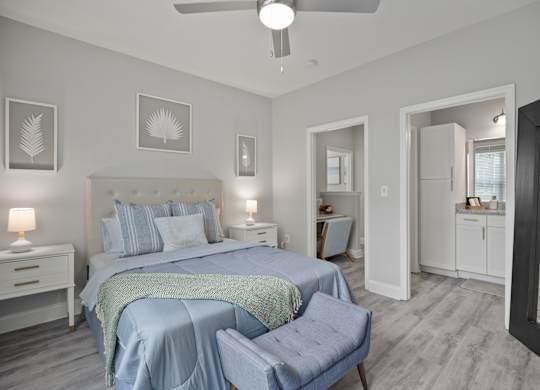 A bedroom with a bed, nightstand, and chair.
