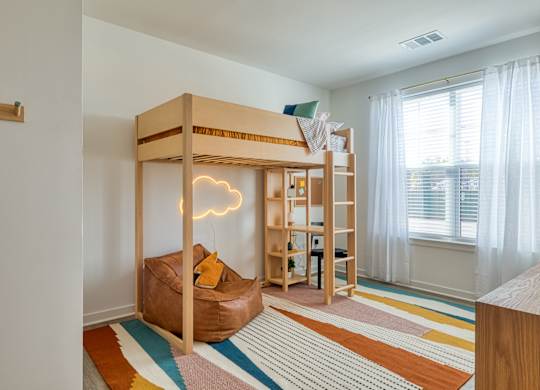 a bunk bed in a room with a desk and a window