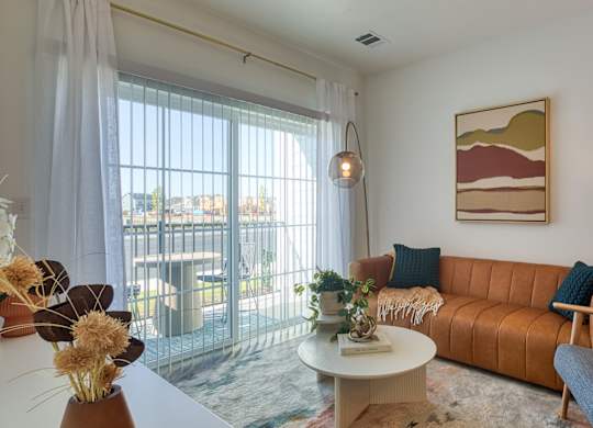 a living room with a couch and a table and a balcony